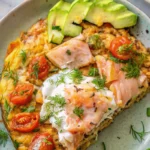 Smoked salmon frittata garnished with dill and cherry tomatoes, served in a cast iron skillet.